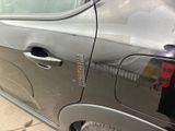 a car that has a broken door handle on the side of the road