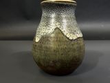 un vase posé sur une table à fond gris