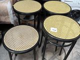 four stools and a table in a room with a couch in the background