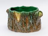 un vase vert et marron orné d'un motif représentant une souche d'arbre