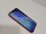 a close up of a red phone on a white table