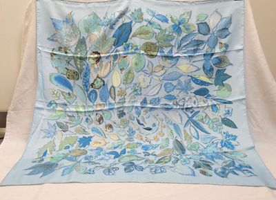 a blue and green floral design on a blue and white blanket