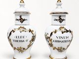 une paire de vases blancs et dorés portant les noms de différents pays