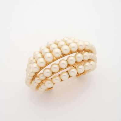 an image of a pearl and gold ring on a white surface