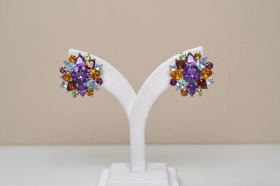 pair of multicolored crystal earrings on a white stand
