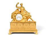 une horloge en or surmontée d'une statue