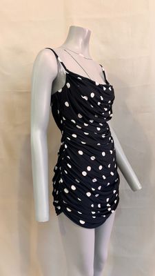 the mannequin is wearing a black dress with white polkas