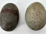 two large rocks sitting next to each other on a white surface