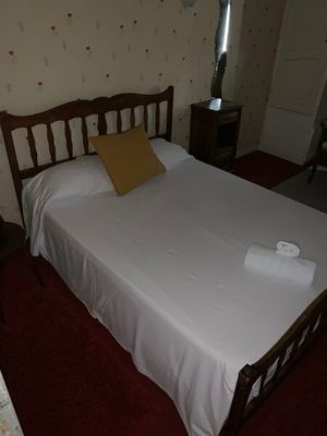 un lit blanc avec une tête de lit en bois dans une chambre