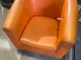 an orange chair that is sitting on the floor