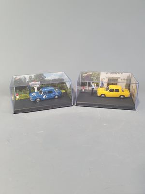 two miniature cars that are sitting in a display case