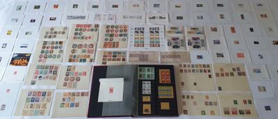 beaucoup de timbres posés sur une table, à côté d'un livre