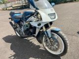 une moto bleue et blanche garée sur un parking