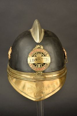 un casque orné d'une décoration dorée, posé sur un socle