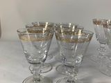 four wine glasses are lined up on a white table