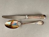 two spoons and a knife sitting on a table