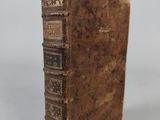 an old book sitting on top of a white surface