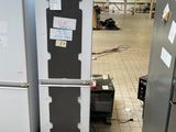 Plusieurs réfrigérateurs sont empilés sur des palettes dans un entrepôt