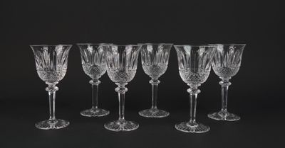 six crystal wine glasses lined up against a black background