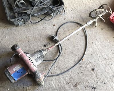 a drill and other tools on the floor in a garage