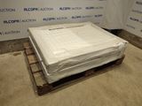 un matelas posé sur une palette devant un mur
