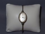 une montre posée sur un oreiller, elle-même posé sur un autre oreiller