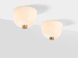 a pair of white and gold sconces on a white surface