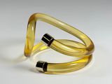 yellow glass bracelet with black accents on a white surface