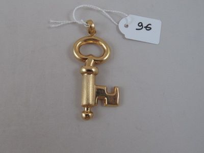 a close up of a gold key with a tag on it