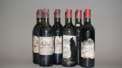 quatre bouteilles de vin sont alignées sur une table
