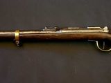 an old rifle is laying on a table next to a wall