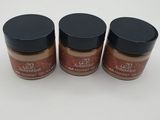 trois pots de poudre couleur chocolat posés sur une surface blanche
