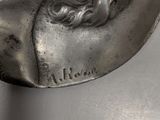 an image of a silver coin with a man ' s face on it