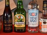 several bottles of alcohol are lined up on a red table