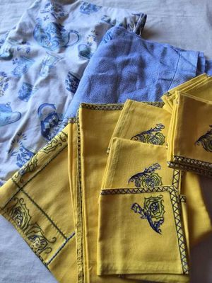 des serviettes jaunes ornées de motifs bleus et jaunes, posées sur un lit
