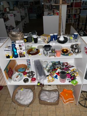une étagère blanche sur laquelle sont posés de nombreux objets, dans une pièce