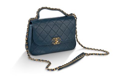 un sac à main bleu avec une bandoulière en chaîne sur fond blanc
