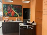 un mur orange dans un restaurant, avec une affiche accrochée au mur