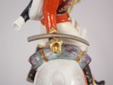 a figurine of a man riding a horse with a sword