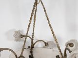 brass and frosted glass chandelier hanging from a ceiling