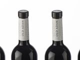 six bottles of wine are lined up in a row on a white surface