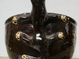 a black vase with gold decorations on it on a table