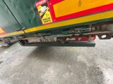 a green and yellow truck parked in a parking lot