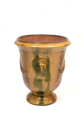 a gold vase with a face on it on a white background