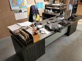 a desk with a laptop and a bunch of papers on it