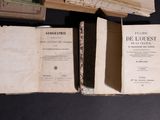 several old books sitting on top of each other on a table