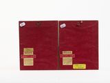 pair of red paper bags with stickers on them sitting on a white surface