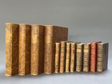 plusieurs vieux livres sont alignés sur une surface grise