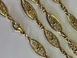 three long gold chains with ornate design on them