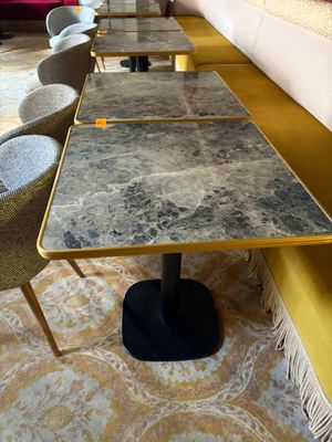 de nombreuses chaises et tables dans une pièce où se trouve un canapé